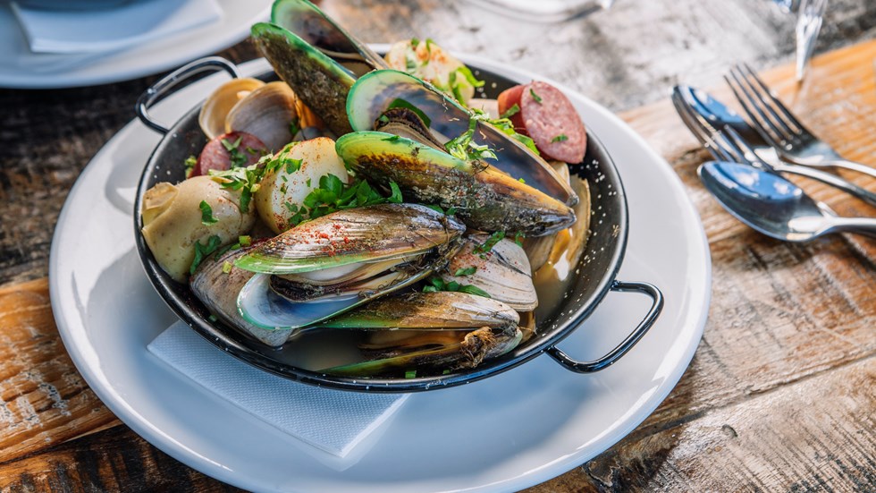 A plate of fresh local Greenshell mussels and clams served at Furneaux Lodge on the Queen Charlotte Track in the Marlborough Sounds, New Zealand.